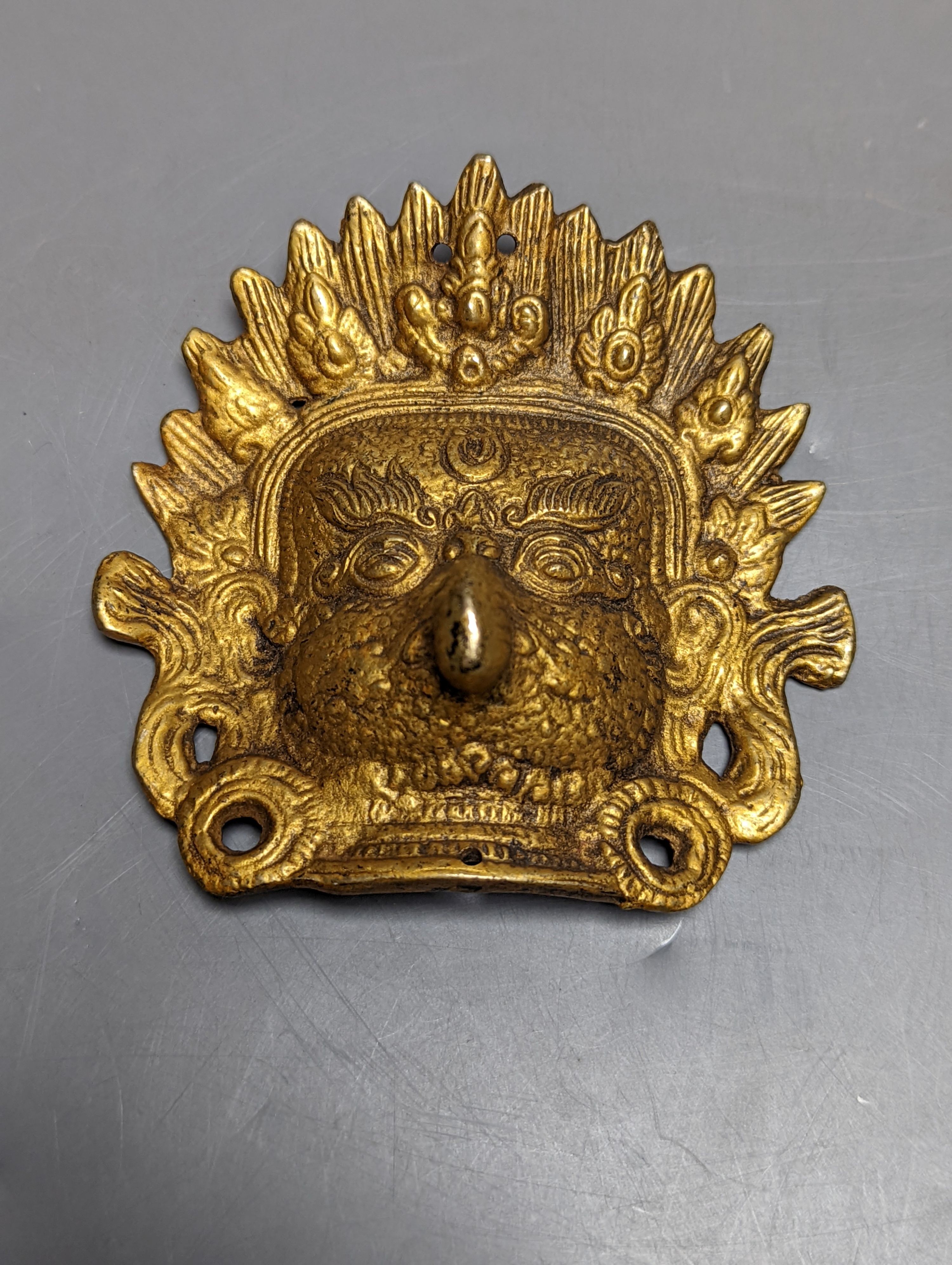 A Chinese jade carving of a resting horse, 7cm and a Himalayan cast gilt-bronze mount